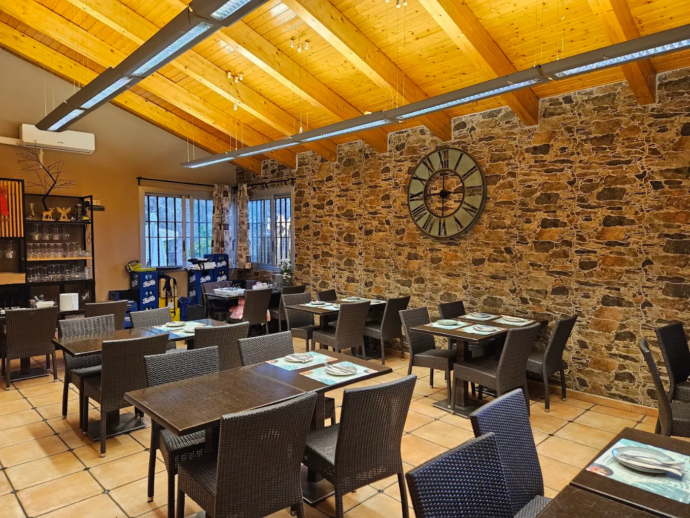 Comedor interior con pared de piedra y techo de madera