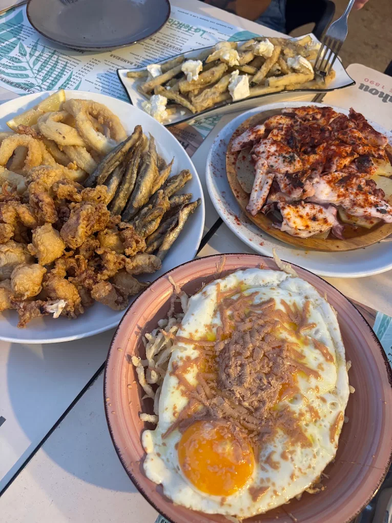 Calamares, boquerones, pulpo y huevo roto con trufa sobre la mesa