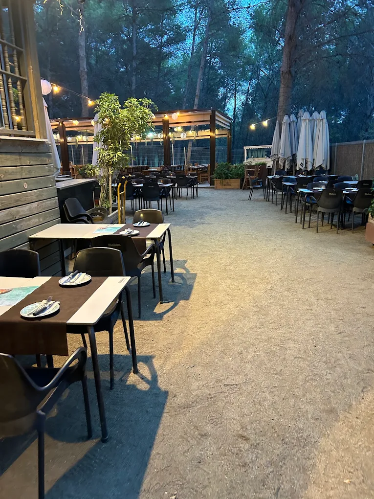Patio exterior con mesas y luces al atardecer